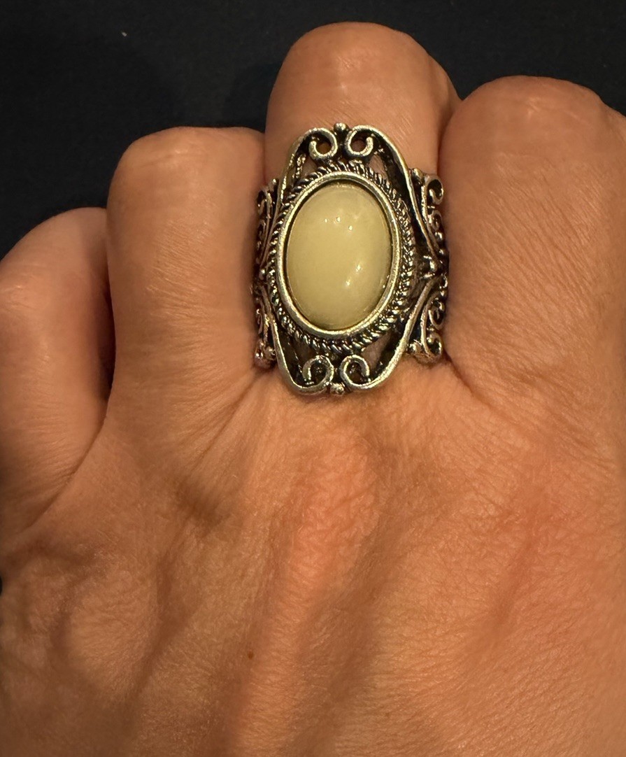 vintage-style ring with white amber cabochon and oxidized silver tone filigree