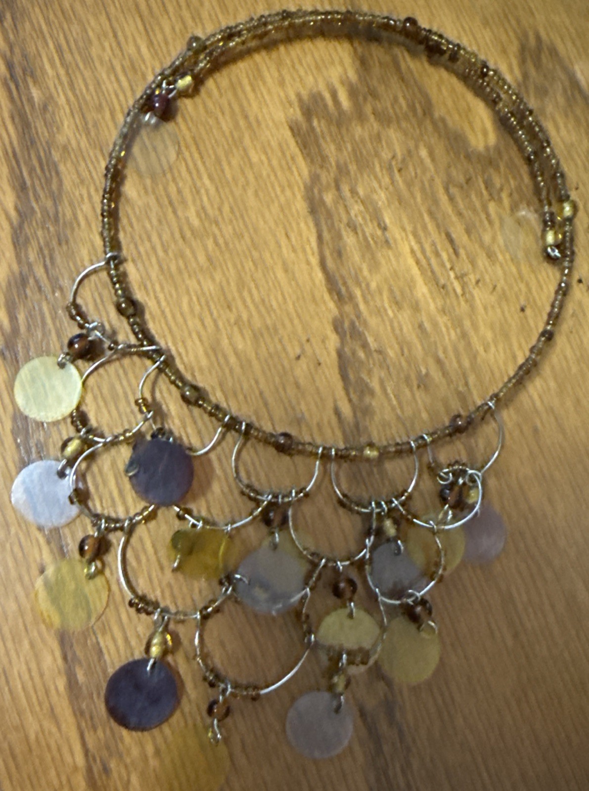 gold-tone seed bead choker necklace with yellow and brown disc pendants.