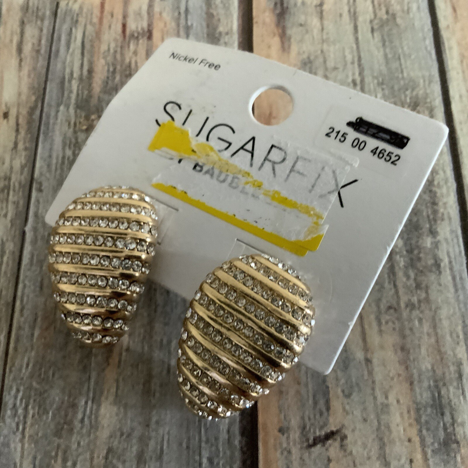 Signed sugarfix rhinestone egg shaped pierced earrings in gold tone