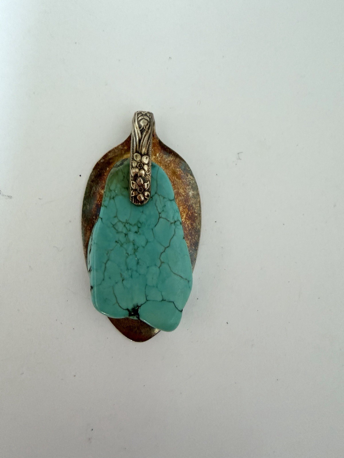 Beautiful silver pendant featuring a turquoise stone set on a decorative bail B5