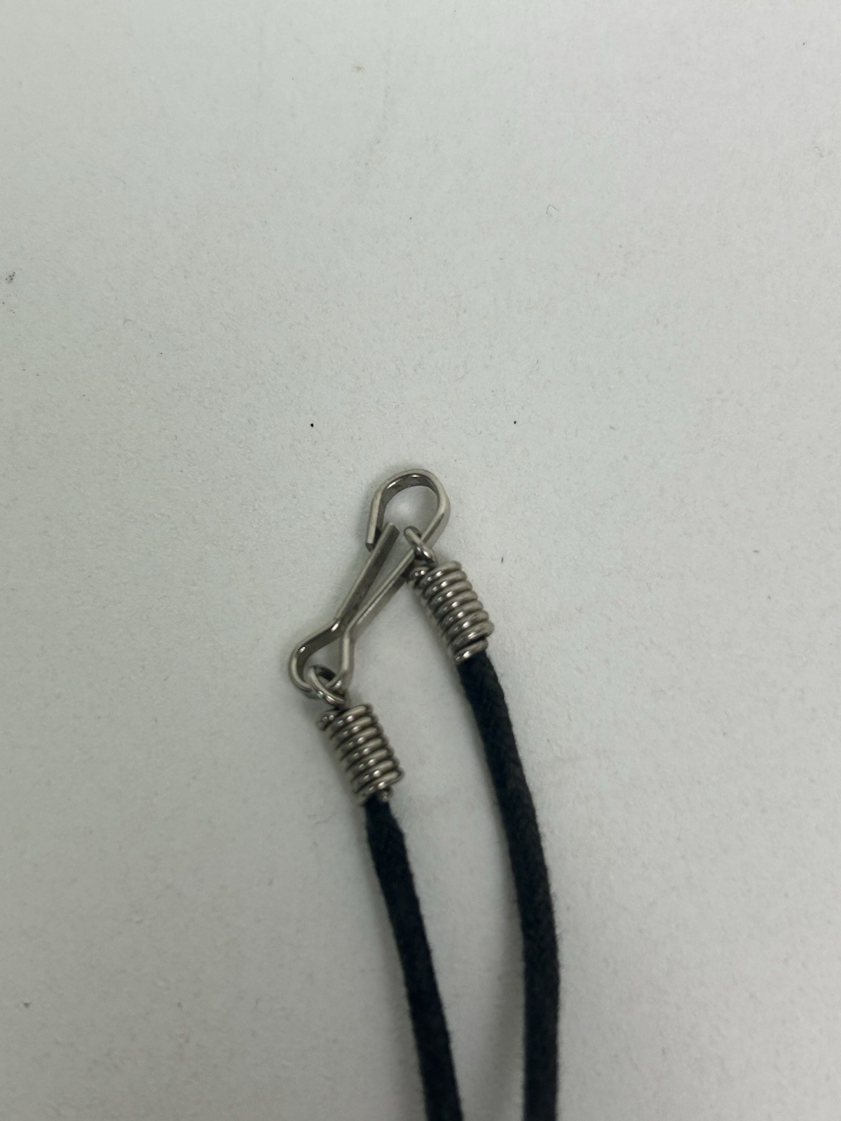 Vintage black cord necklace features a green pendant with “Groovy” inscribed