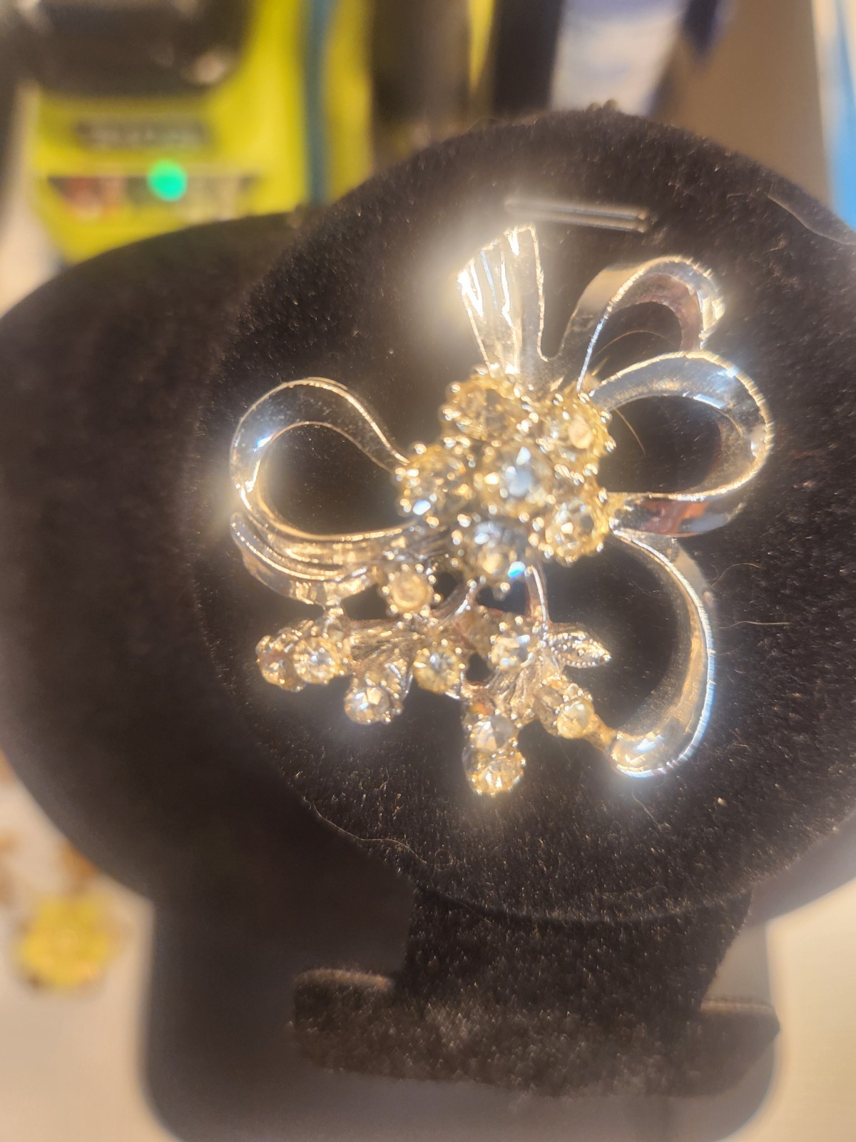 Rhinestone brooch featuring a silver-tone, ribbon bow and floral bouquet design