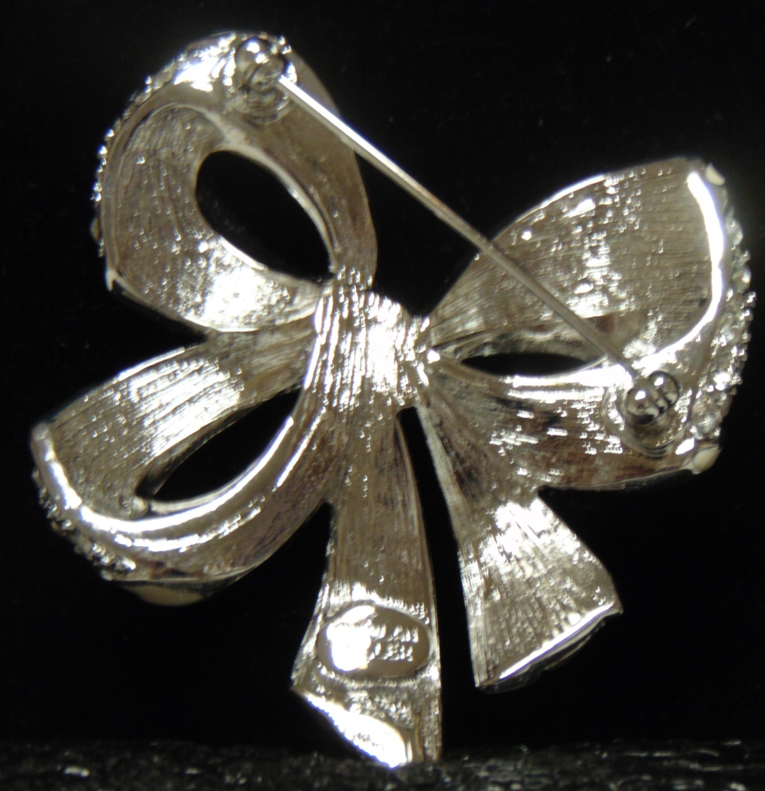 NOLAN MILLER Silver Tone With White Trim and Clear Rhinestones Bow Pin