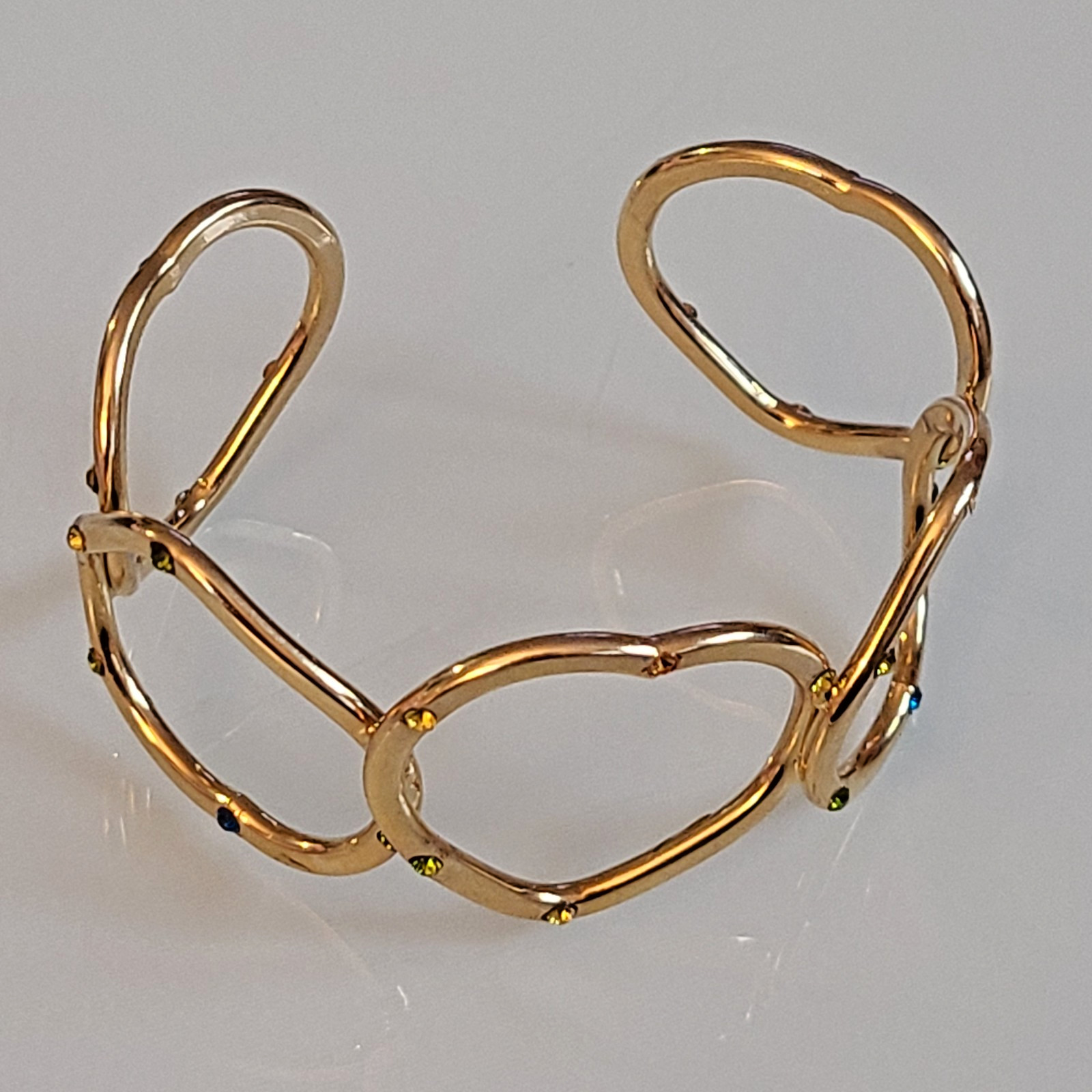 Gold-Tone Open Heart Hinged Cuff Bracelet with Multi-Color Rhinestones.