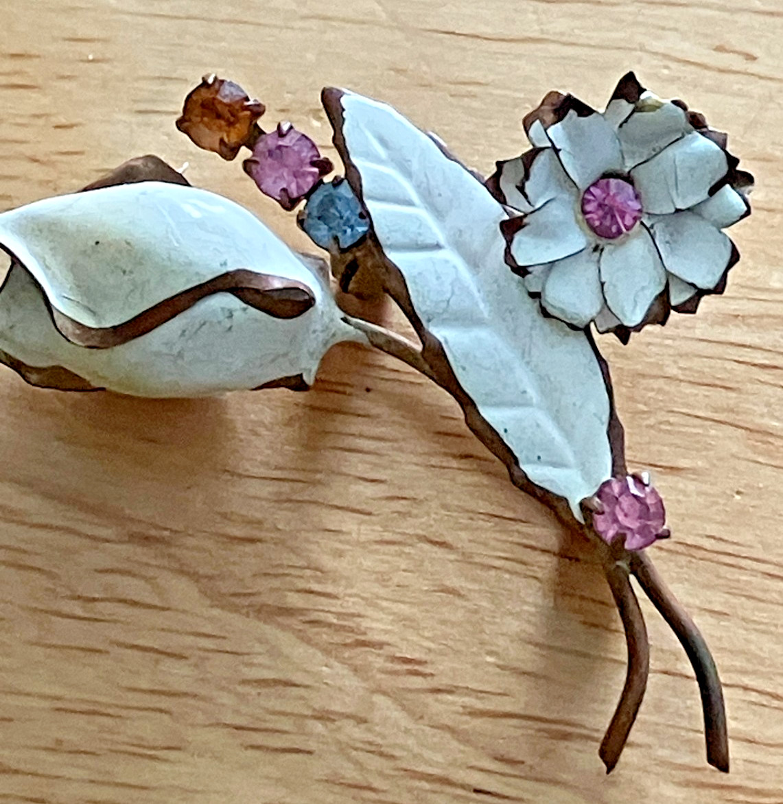 White enamel with multi colored rhinestones floral Pin marked Austria gold tone