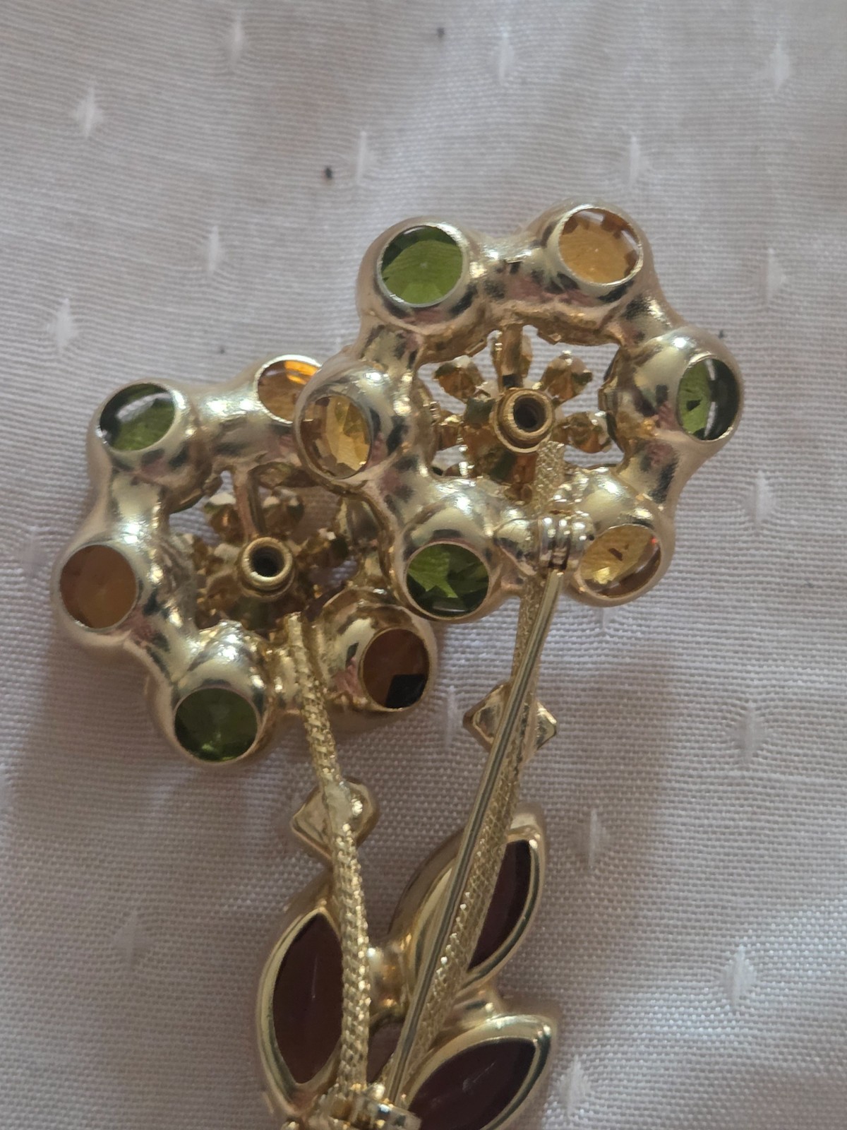 Juliana DeLizza & Elster floral brooch featuring green, amber, and yellow stones
