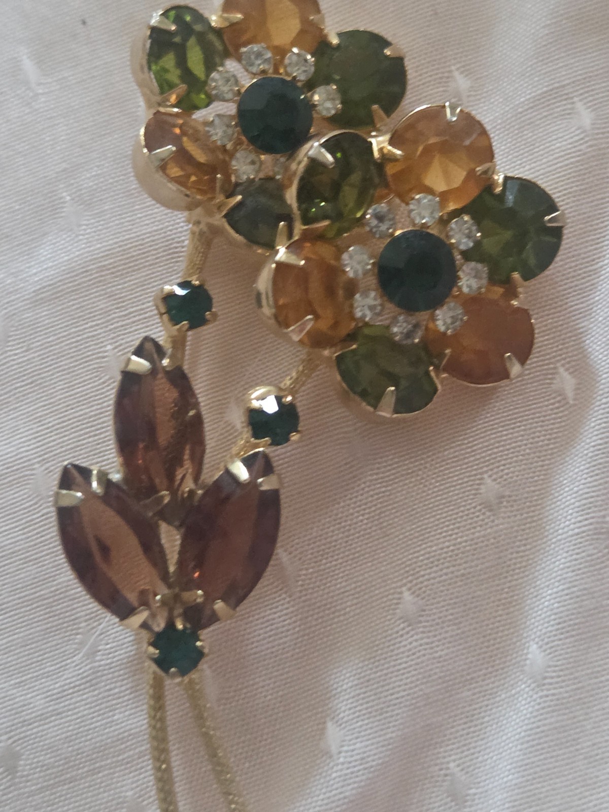 Juliana DeLizza & Elster floral brooch featuring green, amber, and yellow stones