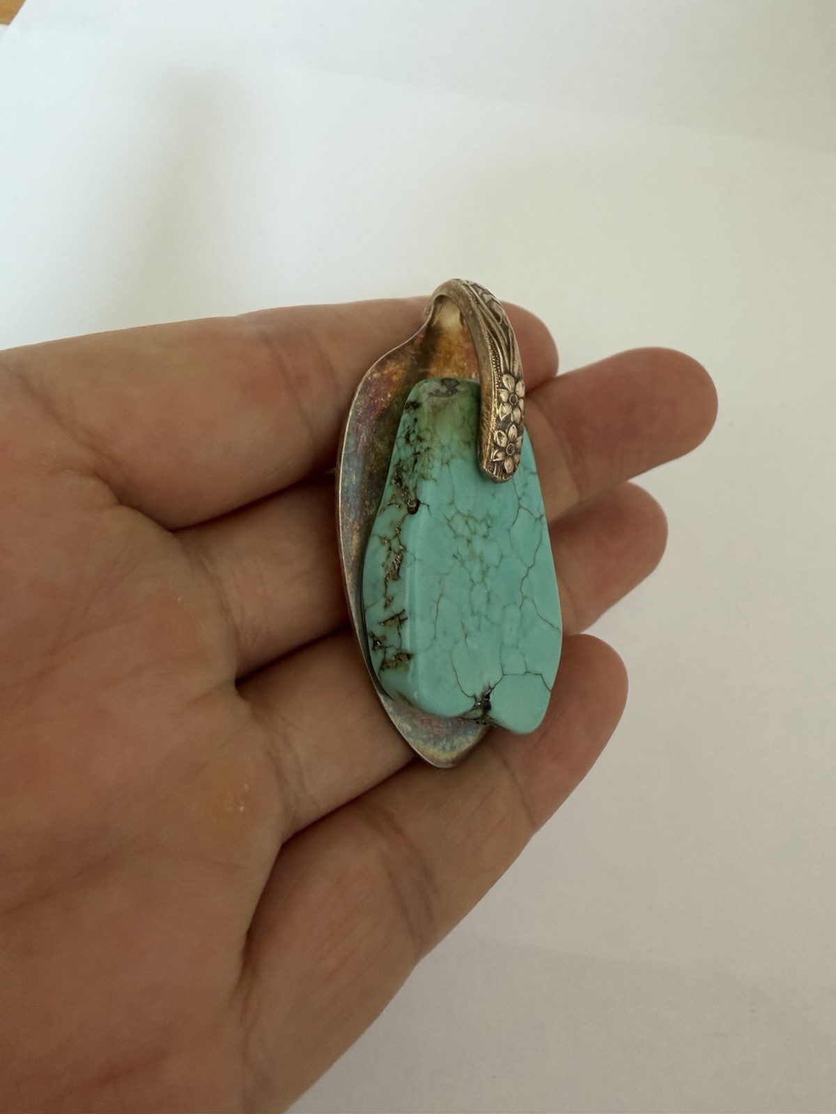 Beautiful silver pendant featuring a turquoise stone set on a decorative bail B5