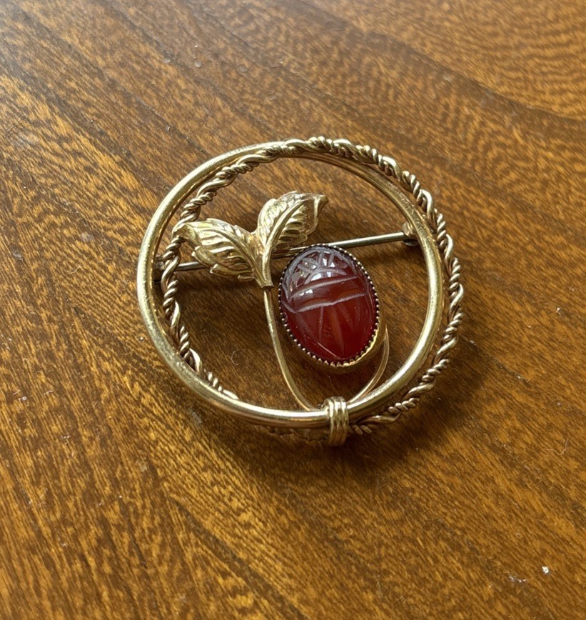 V20 12k “A.C.” Engraved Gold Tone Plant And Red Stone Brooch