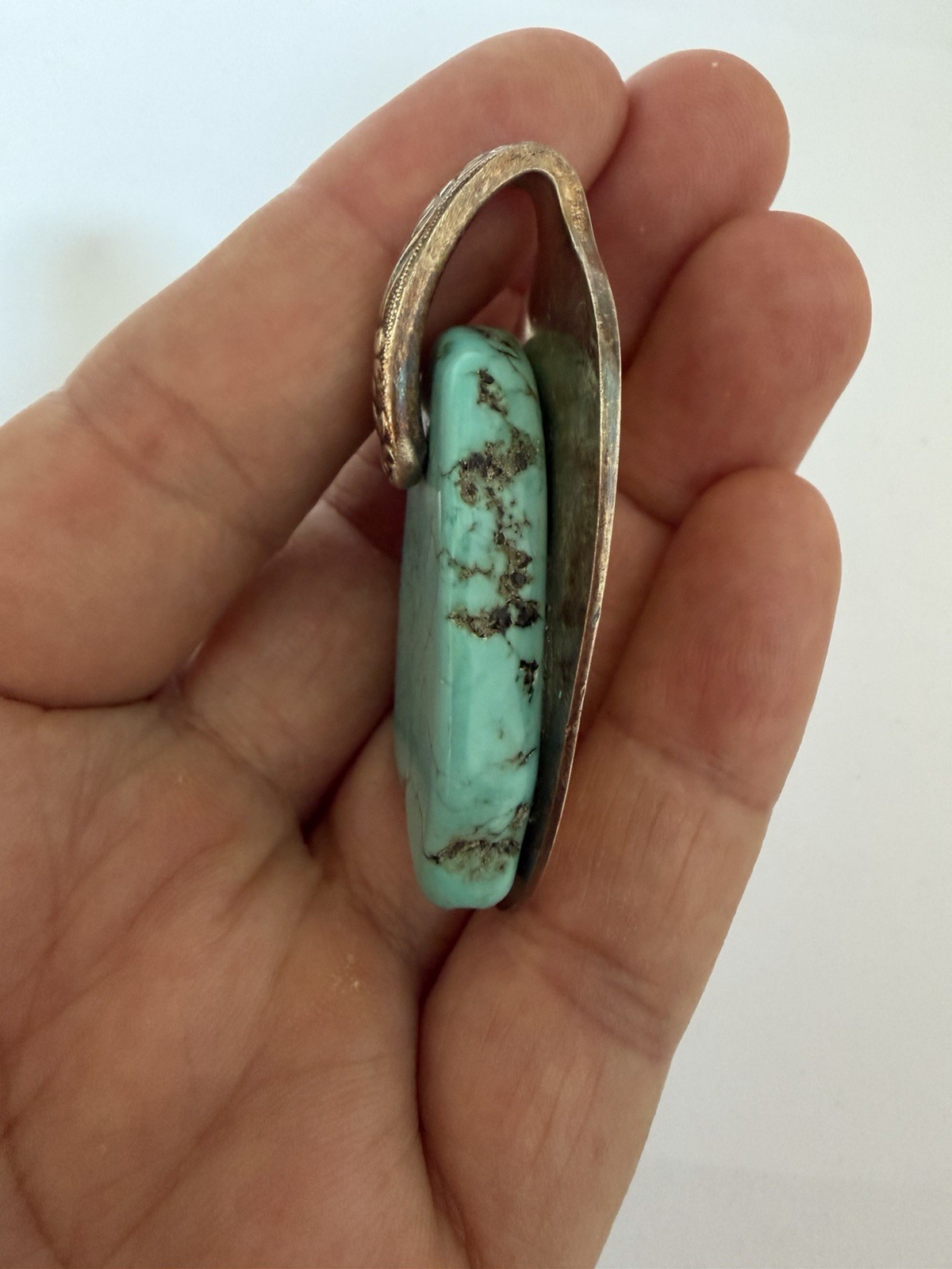 Beautiful silver pendant featuring a turquoise stone set on a decorative bail B5
