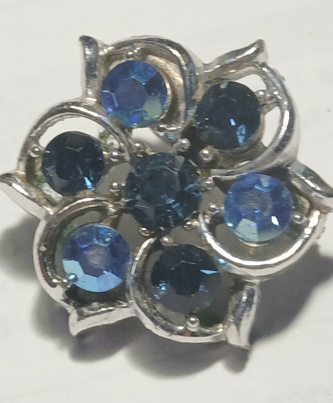 Blue crystals in silver metal setting round brooch/pin