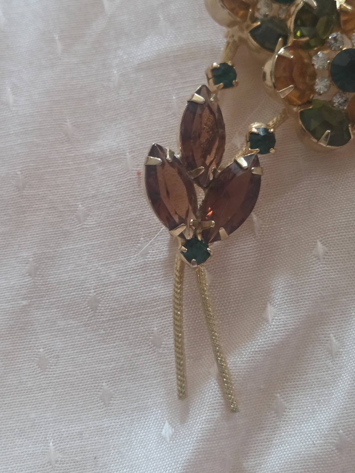 Juliana DeLizza & Elster floral brooch featuring green, amber, and yellow stones
