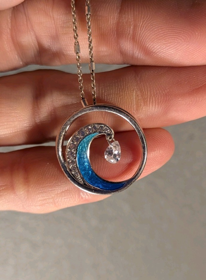 This Is A Wave Inspired Necklace With A And Diamond Pendant That Hangs From The