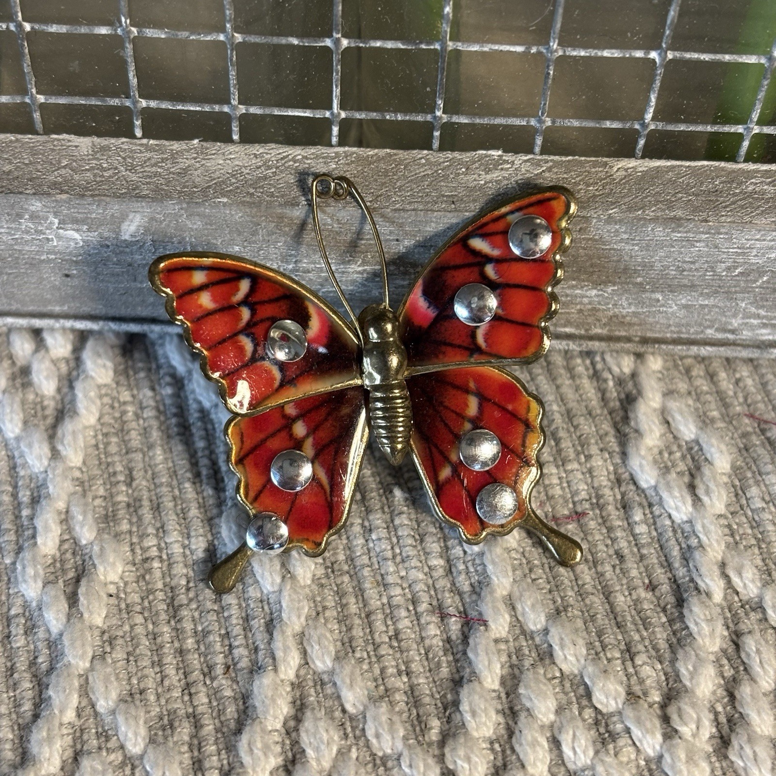 Butterfly Brooch or Pendant of Red Orange and Cream Resin on Gold Tone Setting.