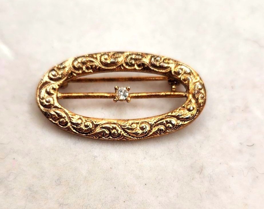Vintage Gold-Tone Oval Brooch With Intricate Scroll Design & Clear Rhinestone Ac