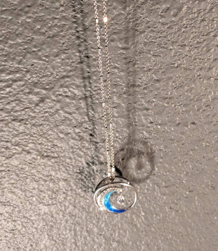 This Is A Wave Inspired Necklace With A And Diamond Pendant That Hangs From The
