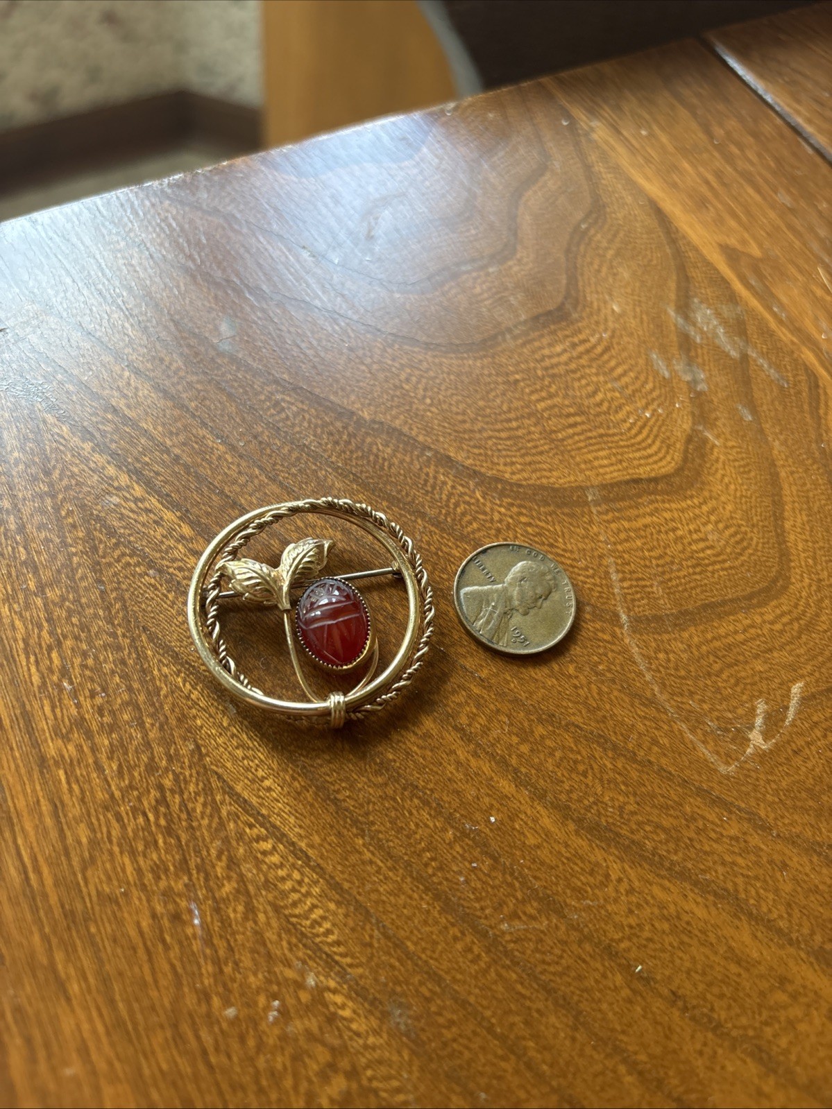 V20 12k “A.C.” Engraved Gold Tone Plant And Red Stone Brooch