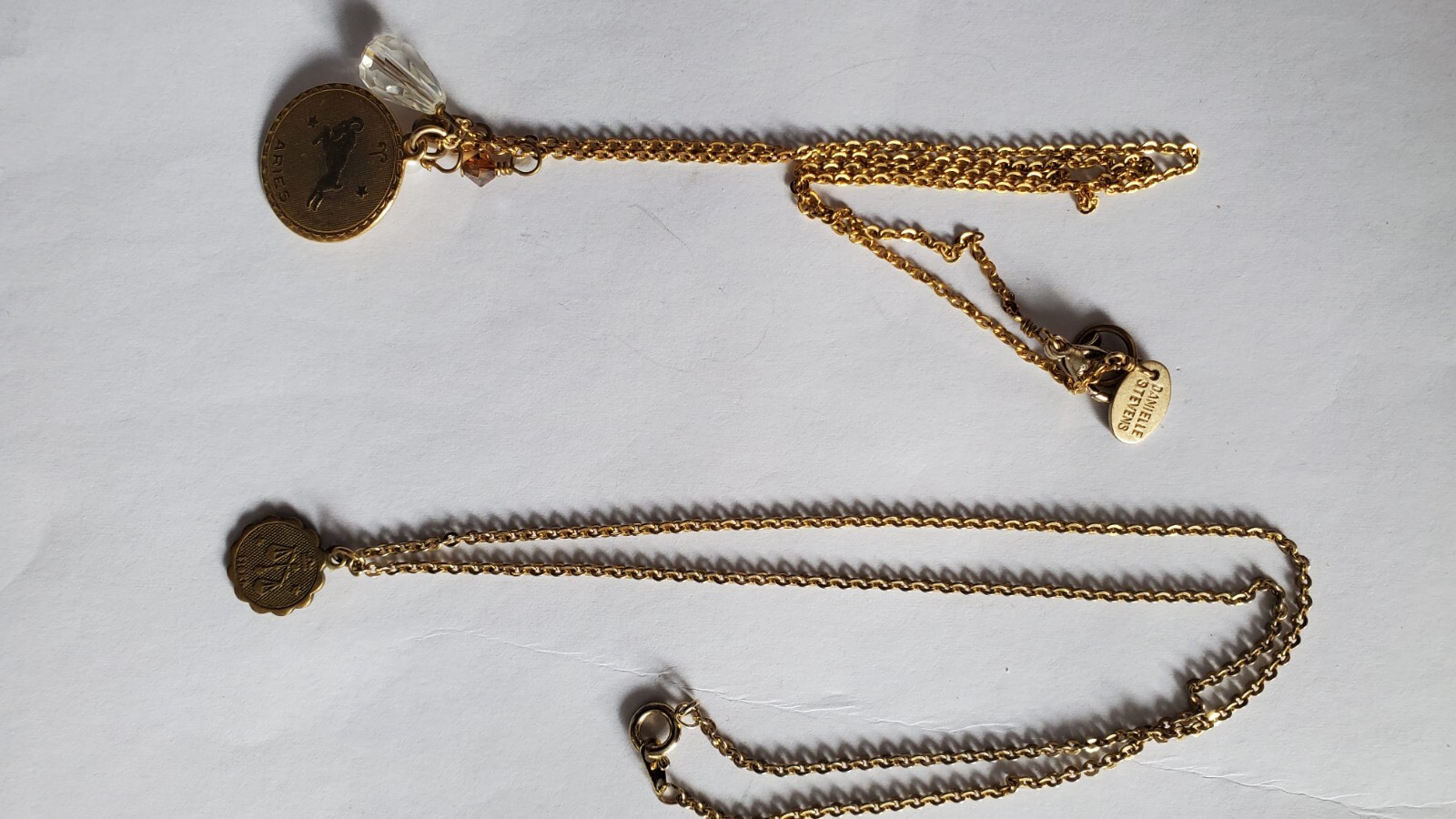 Vintage two gold tone zodiak necklaces, one designer’s Danielle Stevens