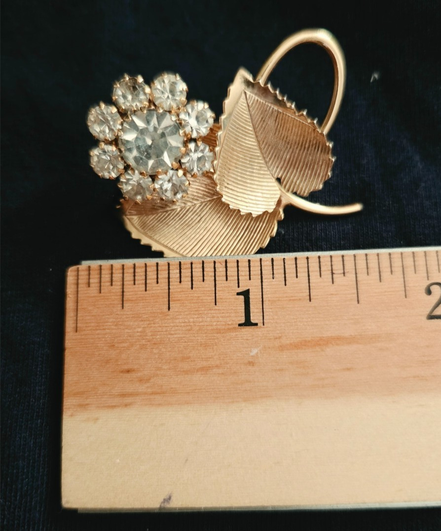 Vintage gold brooch w/two textured leaves and a cluster of clear faceted stones