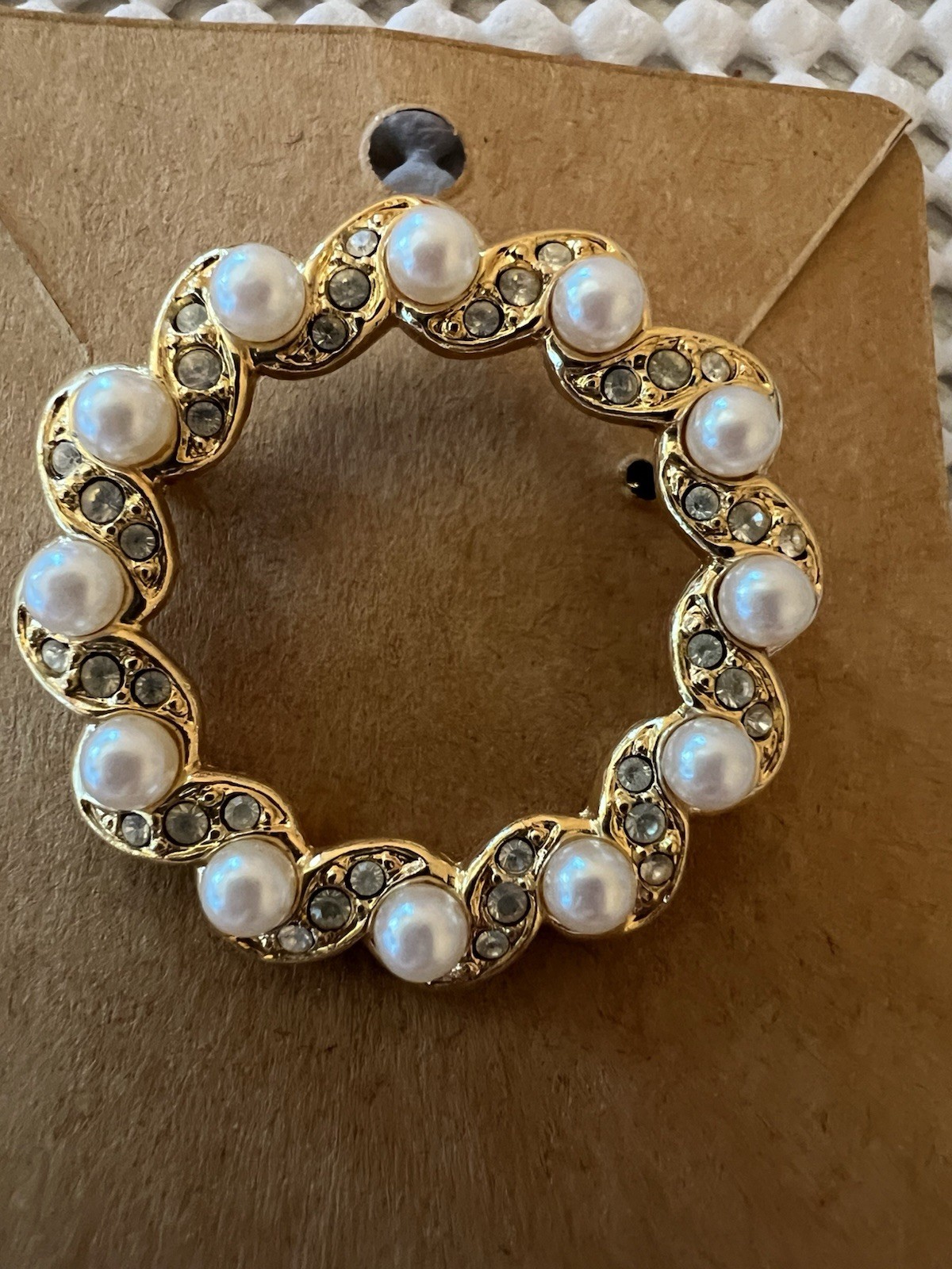 Gold tone pearl and rhinestone pin. 1 1/2 inches across.