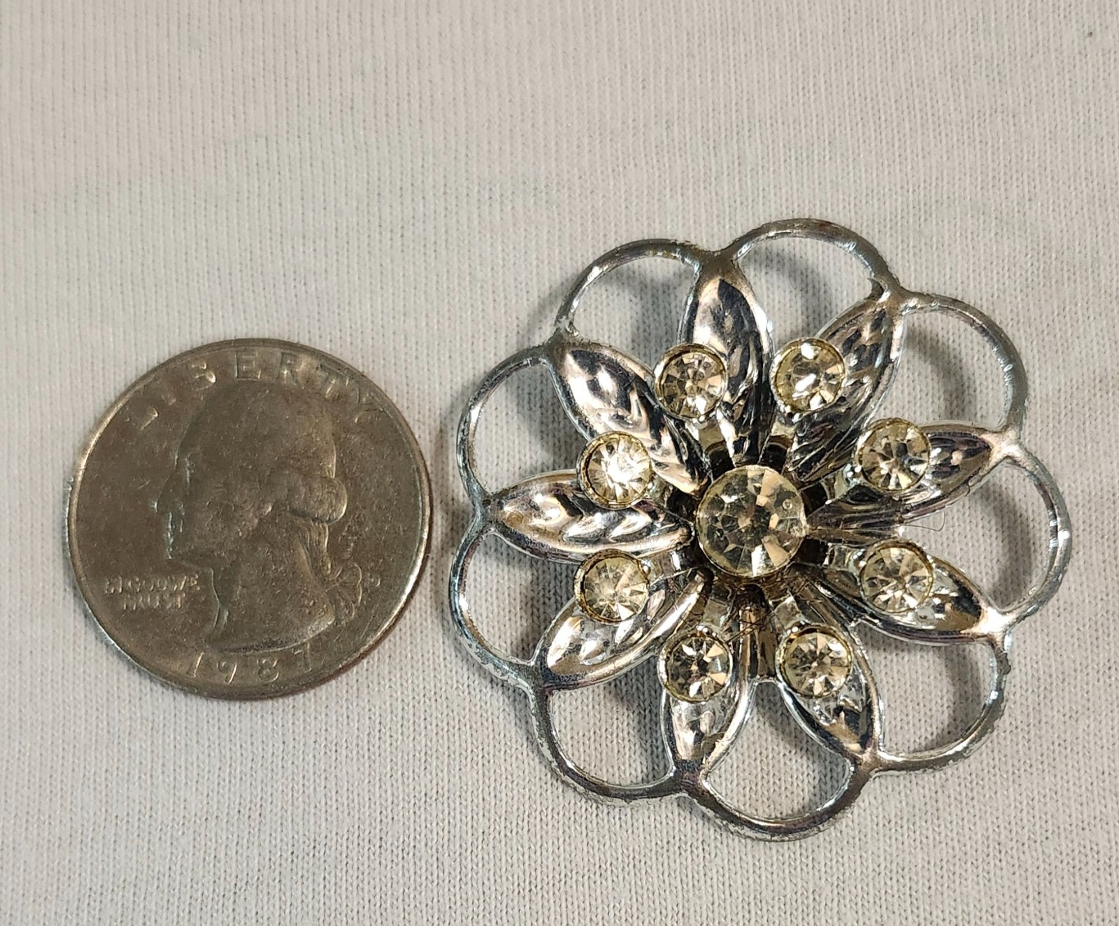 Silver Tone Brooch Flower Design with 8 Small Clear Stones and 1 Larger One