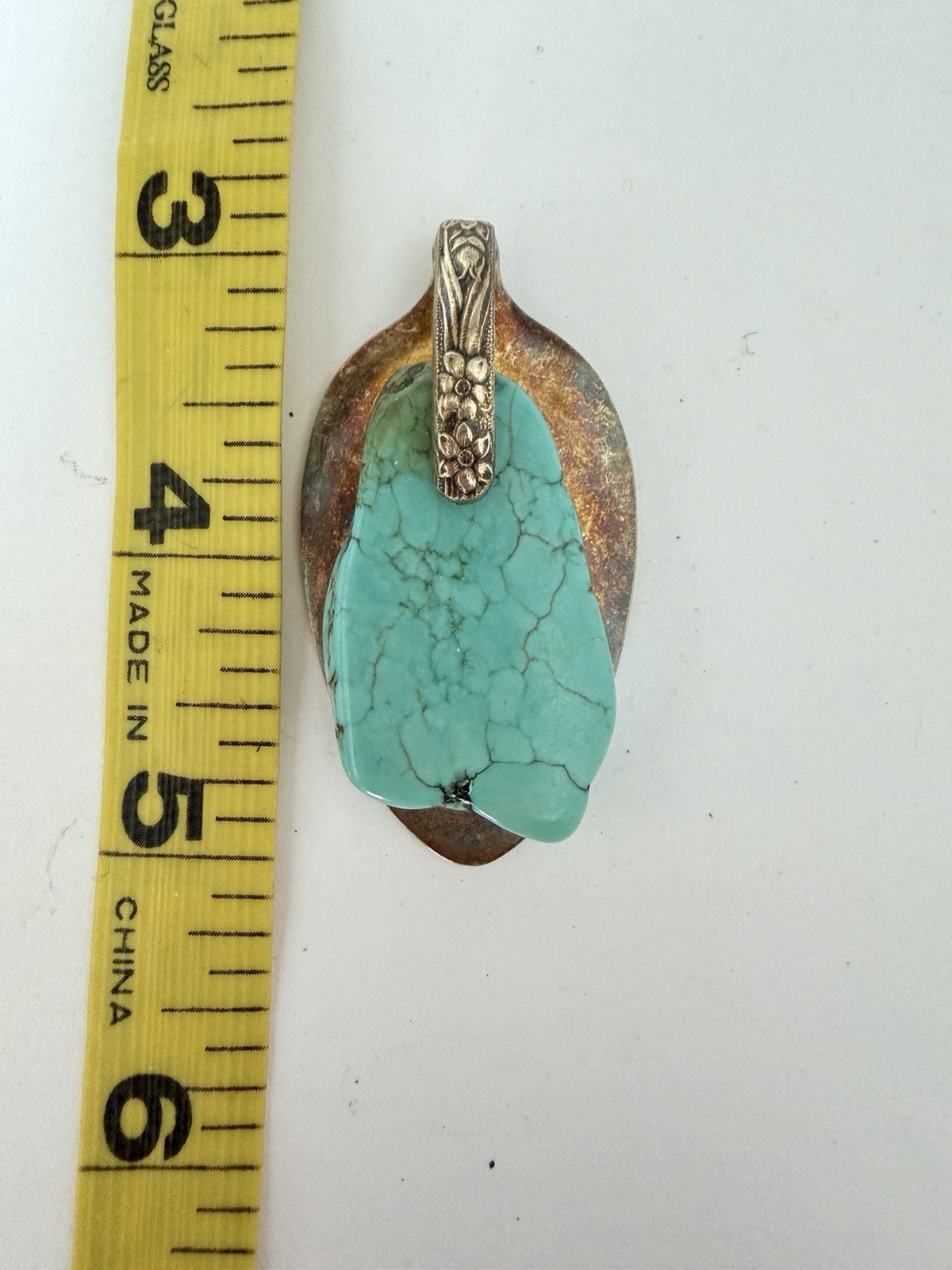 Beautiful silver pendant featuring a turquoise stone set on a decorative bail B5