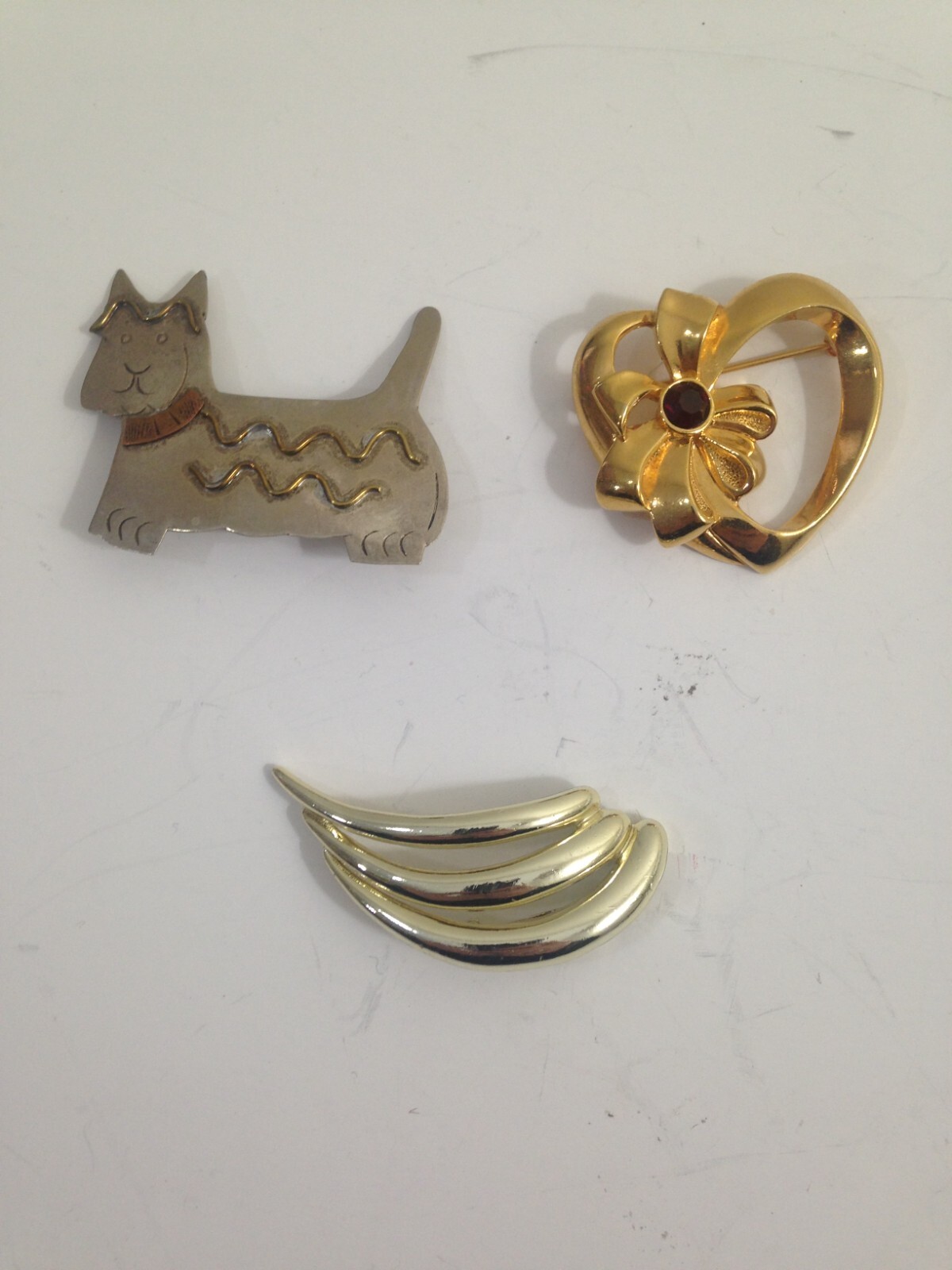 3 brooches – 1 Avon heart w/bow , 1 Pisatelli swoop, 1 unbranded scotty dog lot