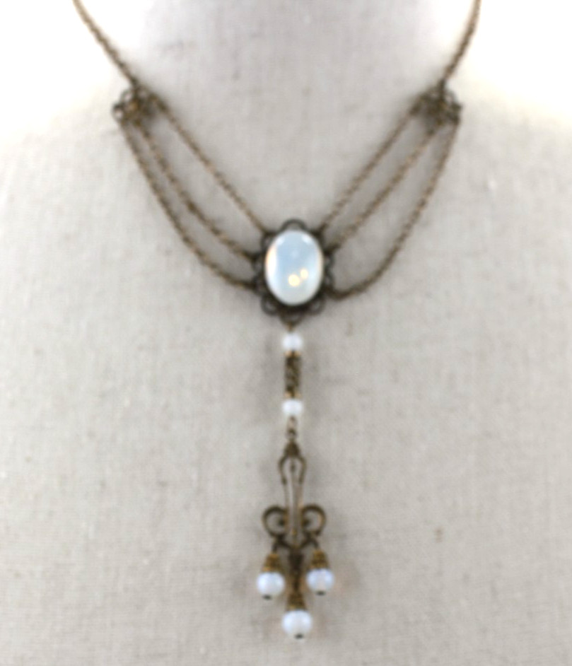 Vintage Style Stamp Brass Festoon Necklace Features an iridescent faux moonstone