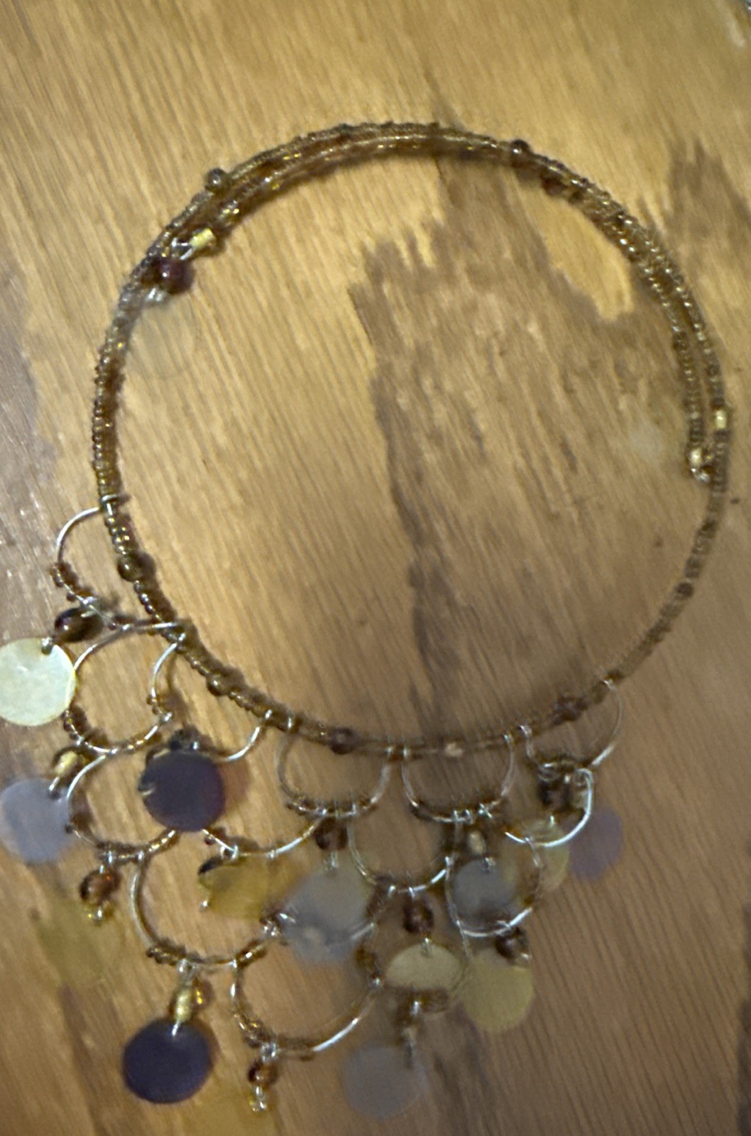 gold-tone seed bead choker necklace with yellow and brown disc pendants.