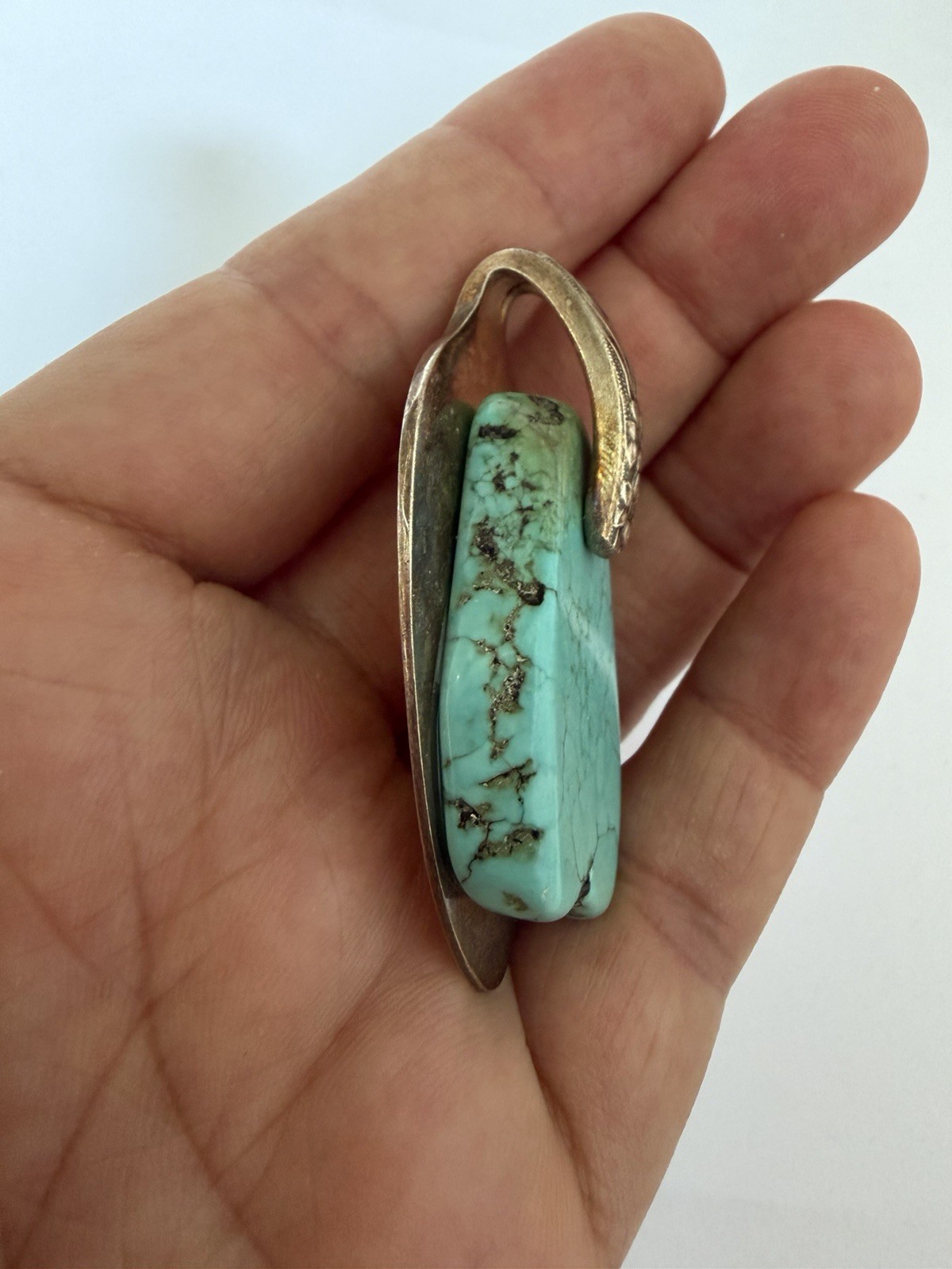 Beautiful silver pendant featuring a turquoise stone set on a decorative bail B5