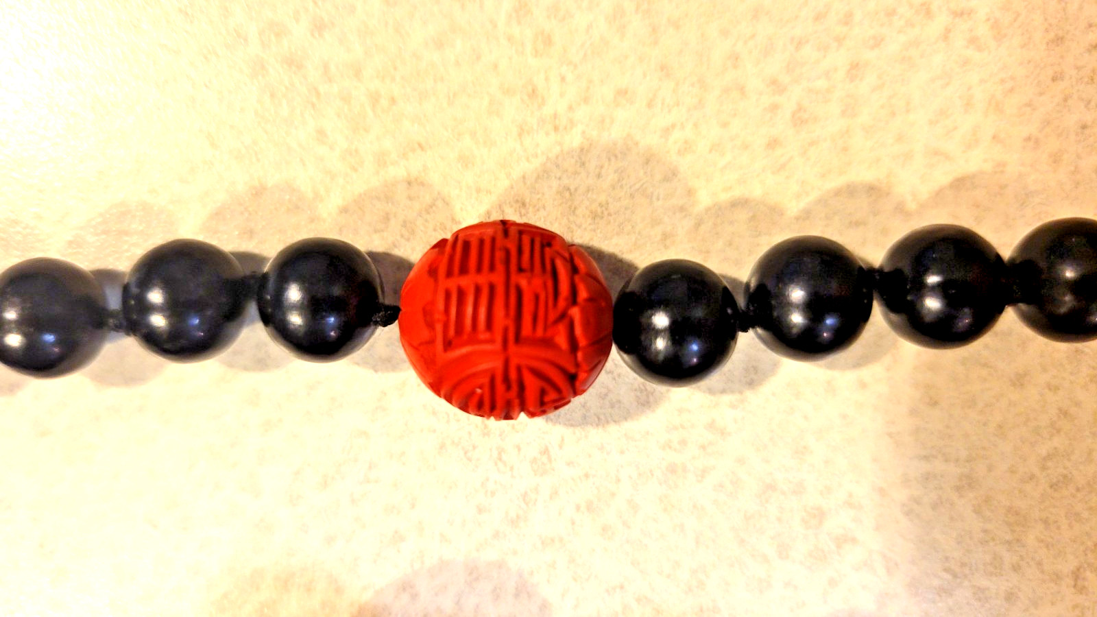 Cinnabar and black obsidion necklase 30″ hand knotted no clasp. 11 carved red lg