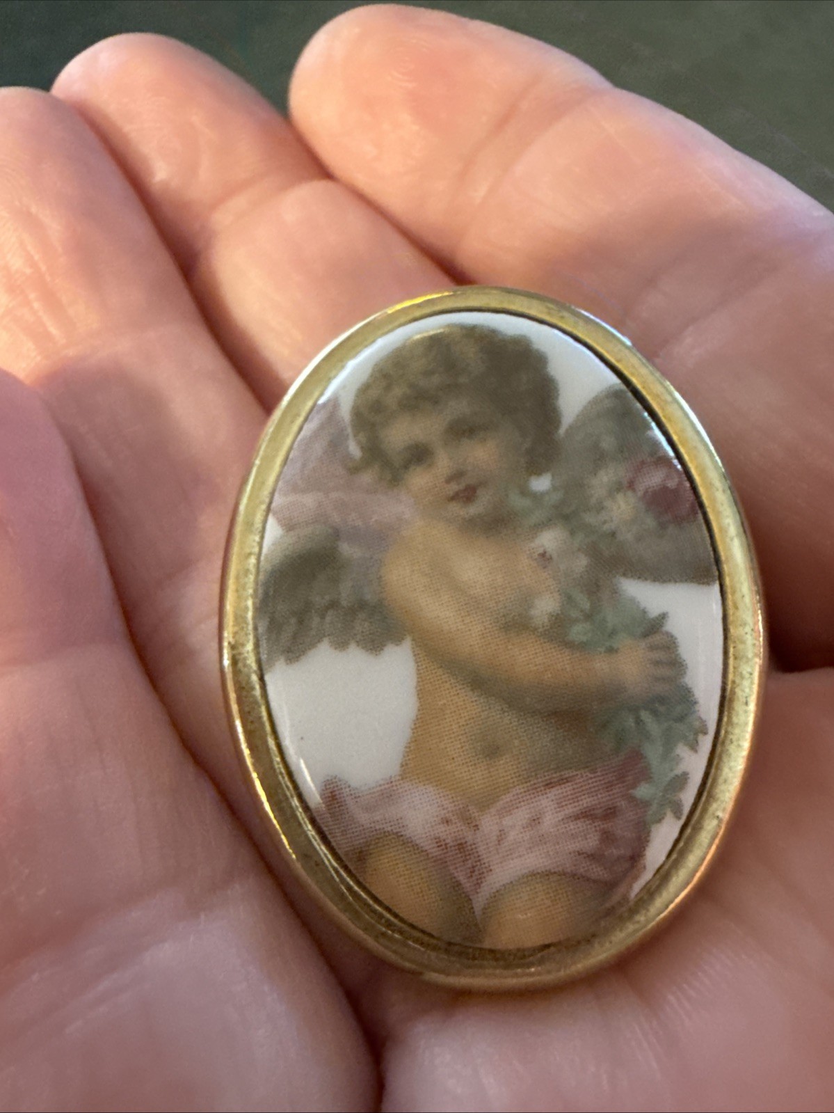 Vintage porcelain cherub or angel brooch with a gold-toned frame. 1 1/2 “