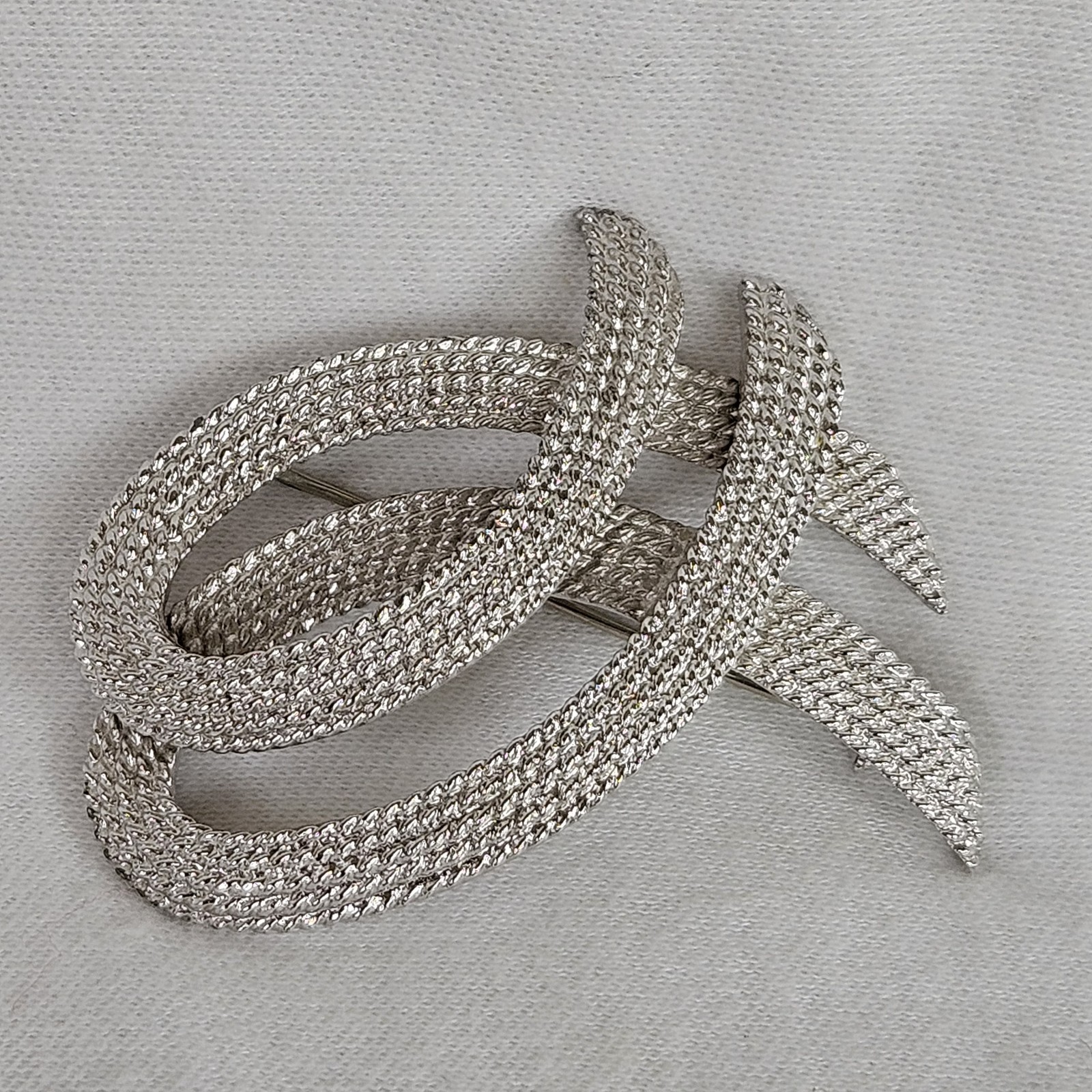 Vintage Monet Silvertone TEXTURED Twisted Ribbon Brooch approximately 2-1/8”