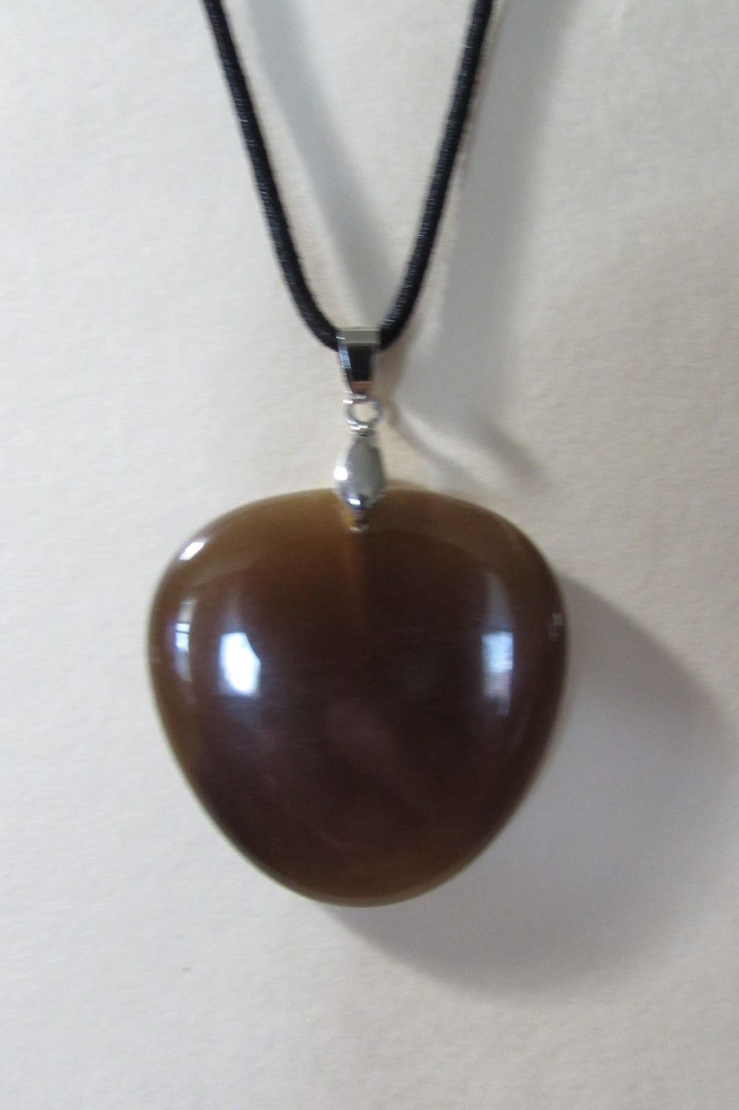 18″ long black stretchy cord necklace with almost 2″ brown smooth stone/rock fob