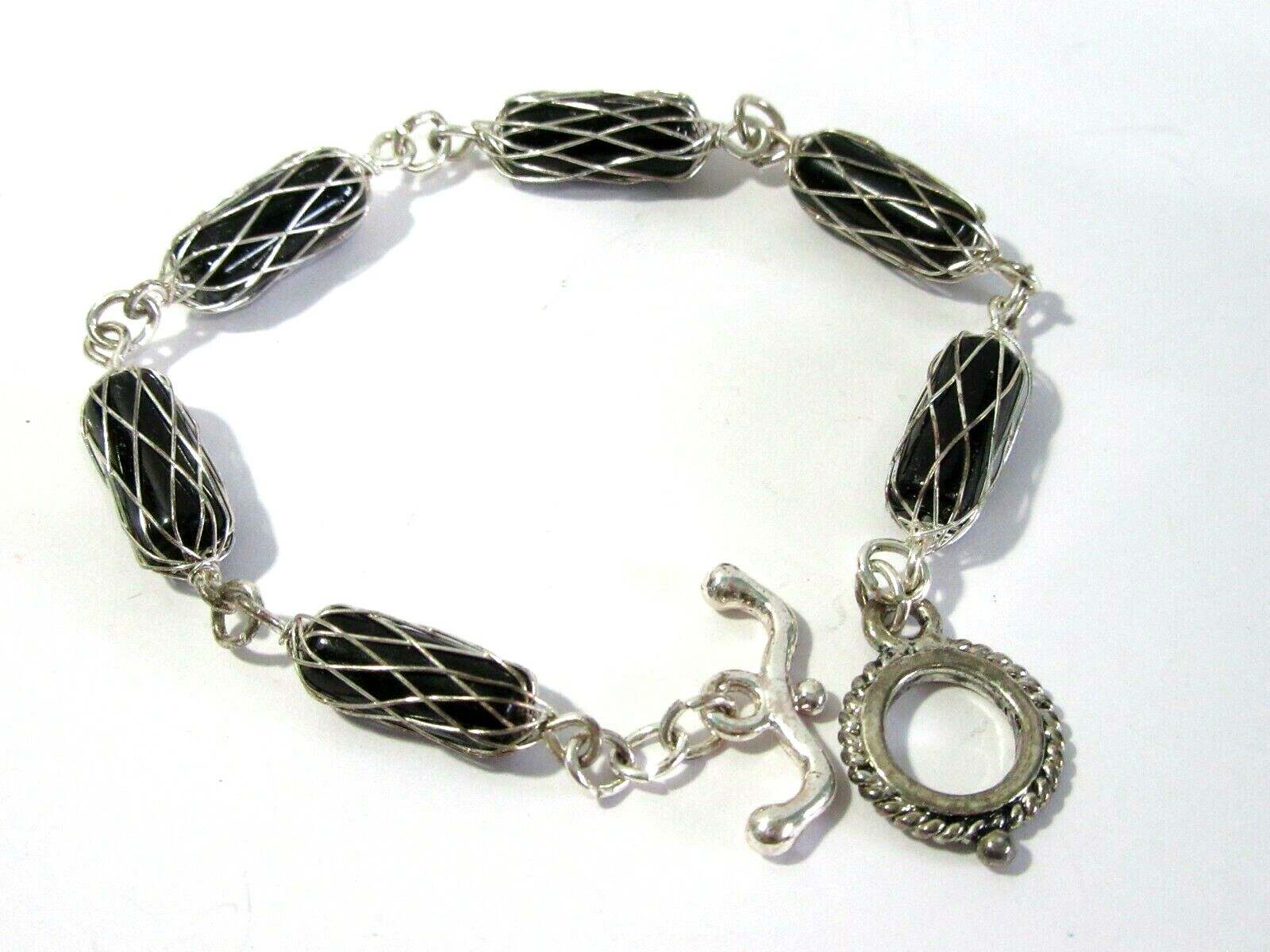 BLACK TUBE BEAD BRACELET WITH SILVER TONE WIRE WRAP CAGED DESIGN TOGGLE CLASP