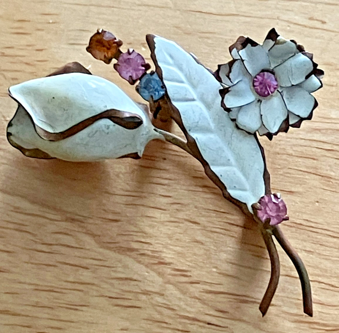 White enamel with multi colored rhinestones floral Pin marked Austria gold tone