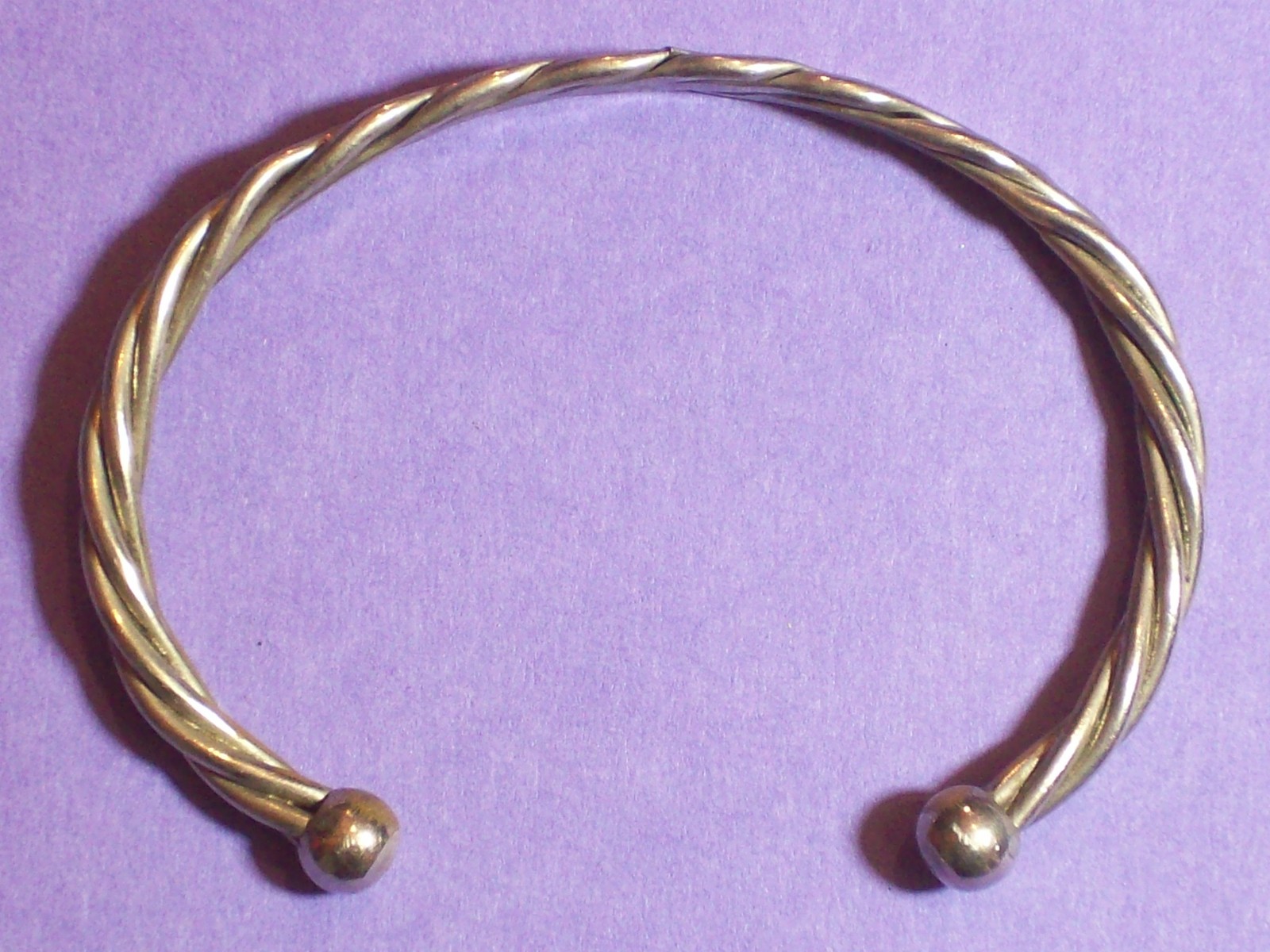 BRACELET ROPE STYLE SILVERY APPEARANCE 2 ¼” ACROSS INSIDE x 1 5/8” WIDE.