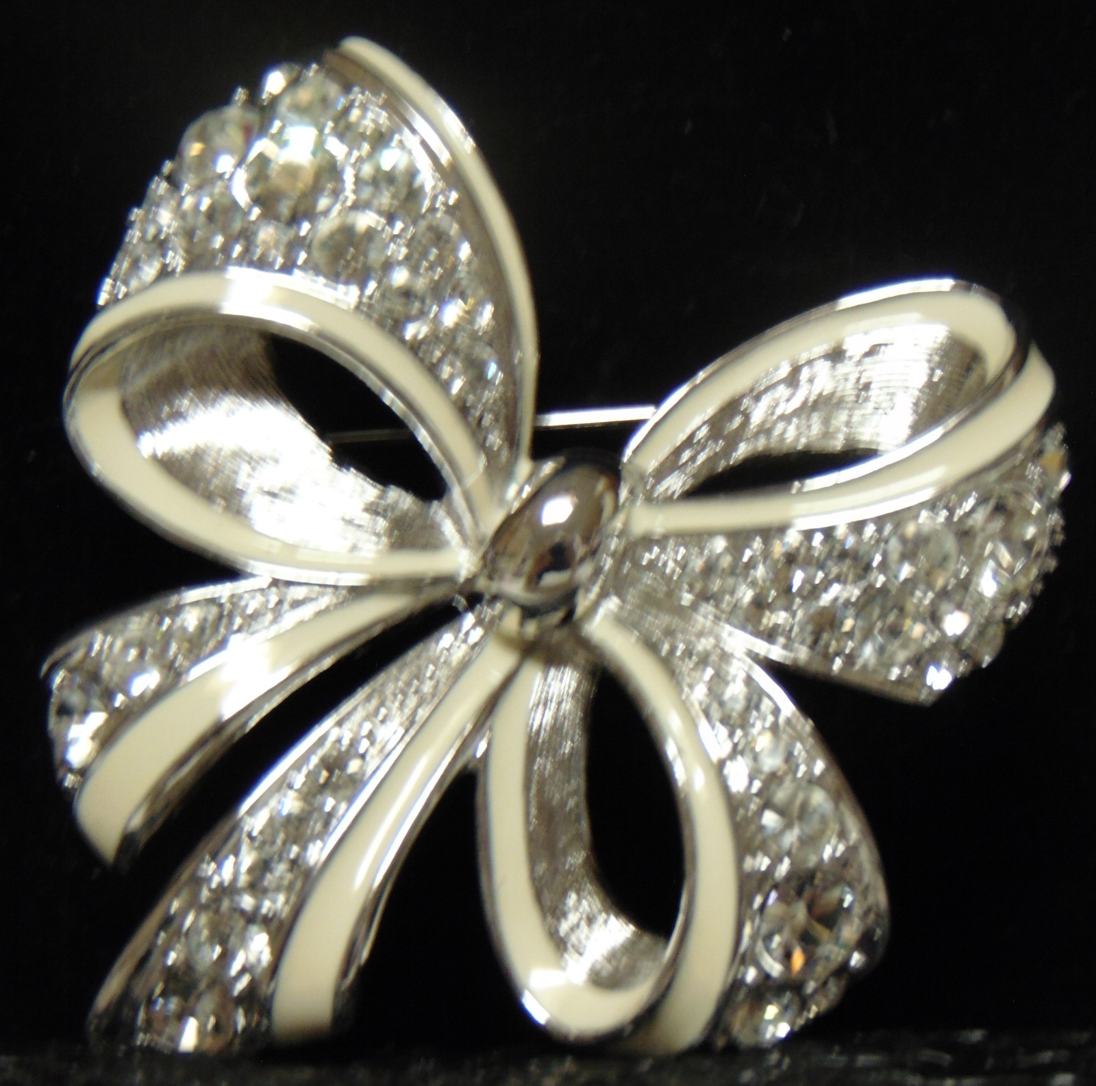 NOLAN MILLER Silver Tone With White Trim and Clear Rhinestones Bow Pin