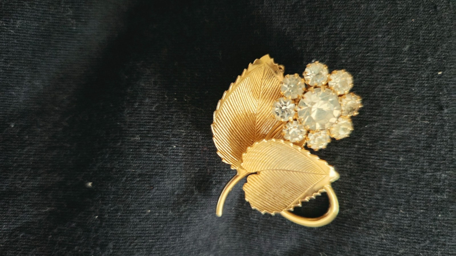 Vintage gold brooch w/two textured leaves and a cluster of clear faceted stones