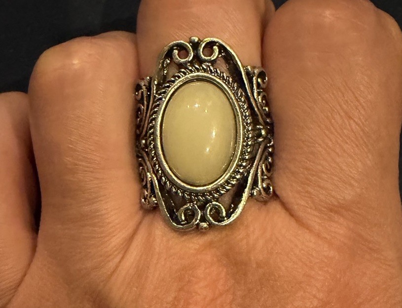 vintage-style ring with white amber cabochon and oxidized silver tone filigree