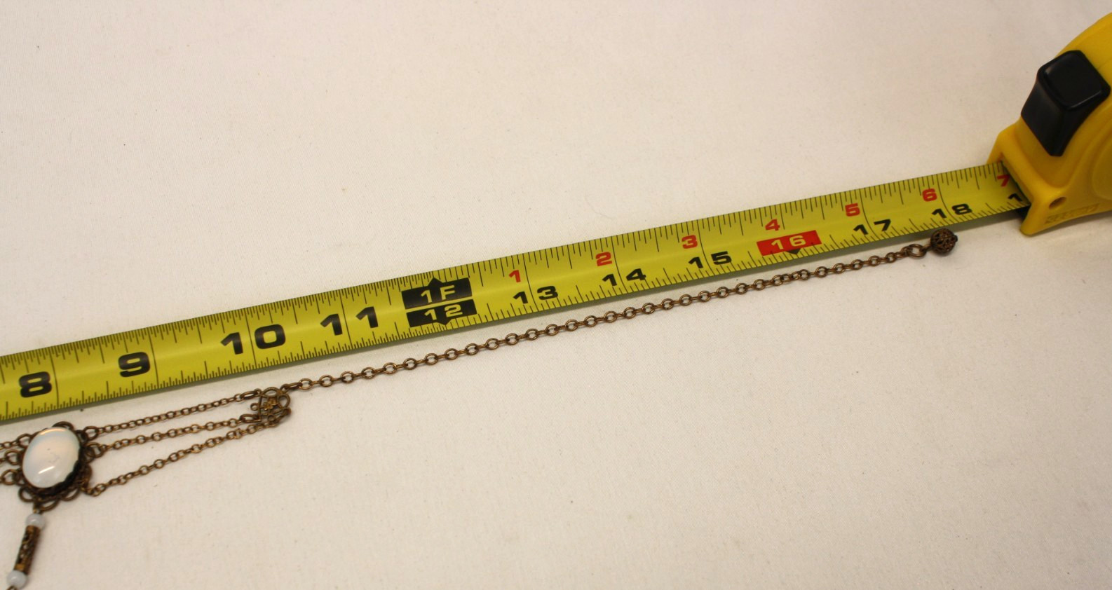 Vintage Style Stamp Brass Festoon Necklace Features an iridescent faux moonstone