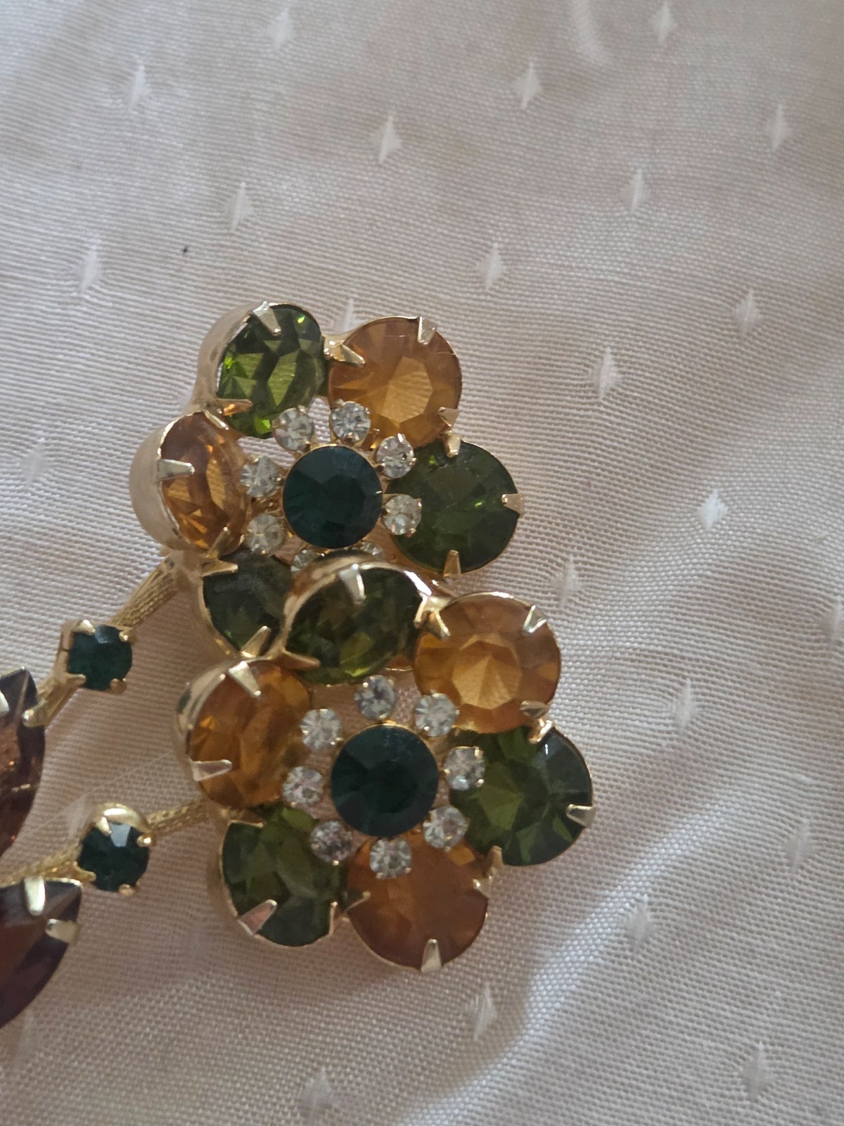 Juliana DeLizza & Elster floral brooch featuring green, amber, and yellow stones
