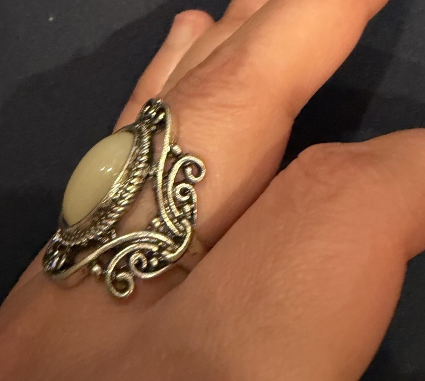 vintage-style ring with white amber cabochon and oxidized silver tone filigree