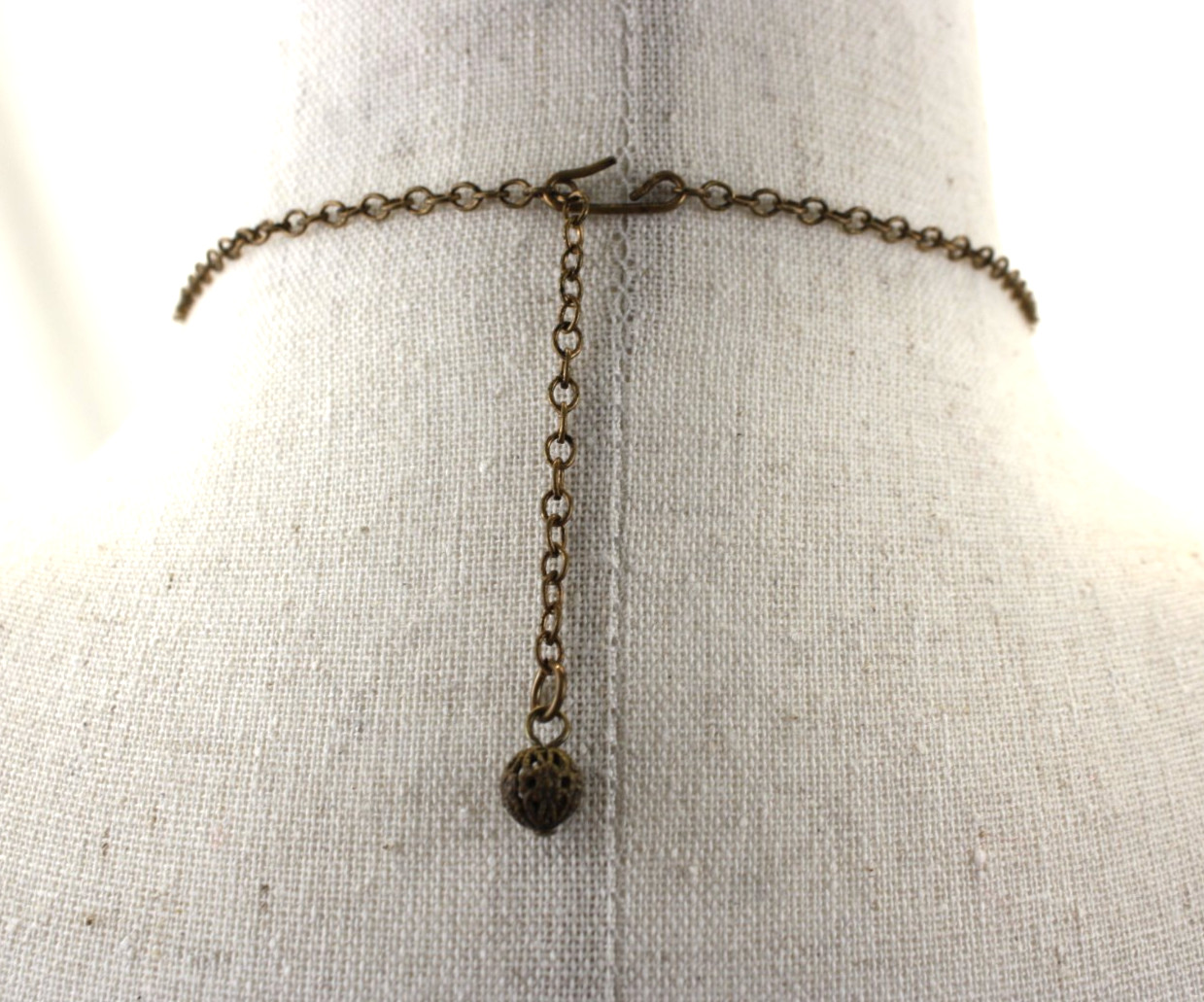 Vintage Style Stamp Brass Festoon Necklace Features an iridescent faux moonstone