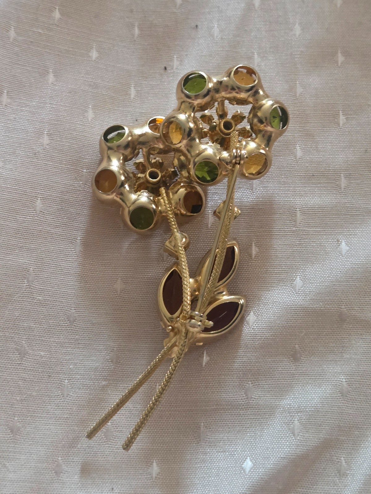 Juliana DeLizza & Elster floral brooch featuring green, amber, and yellow stones